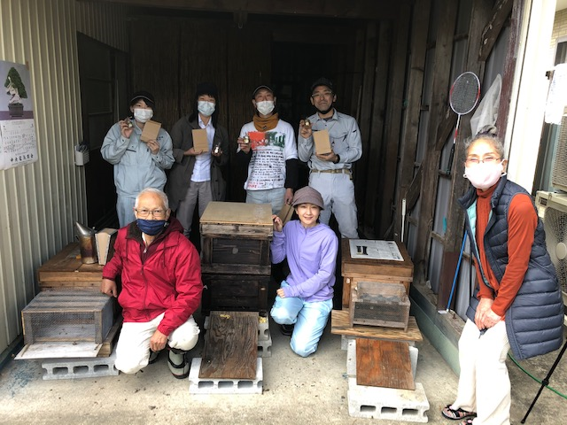 養蜂場で並んで記念撮影をしている人達の写真