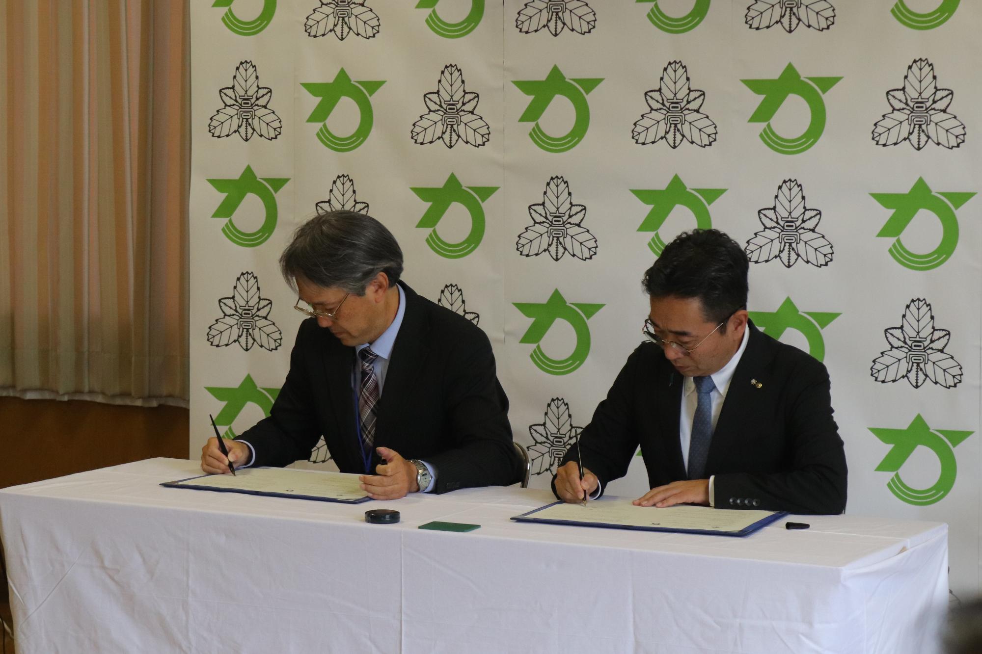 締結書にサインする町長