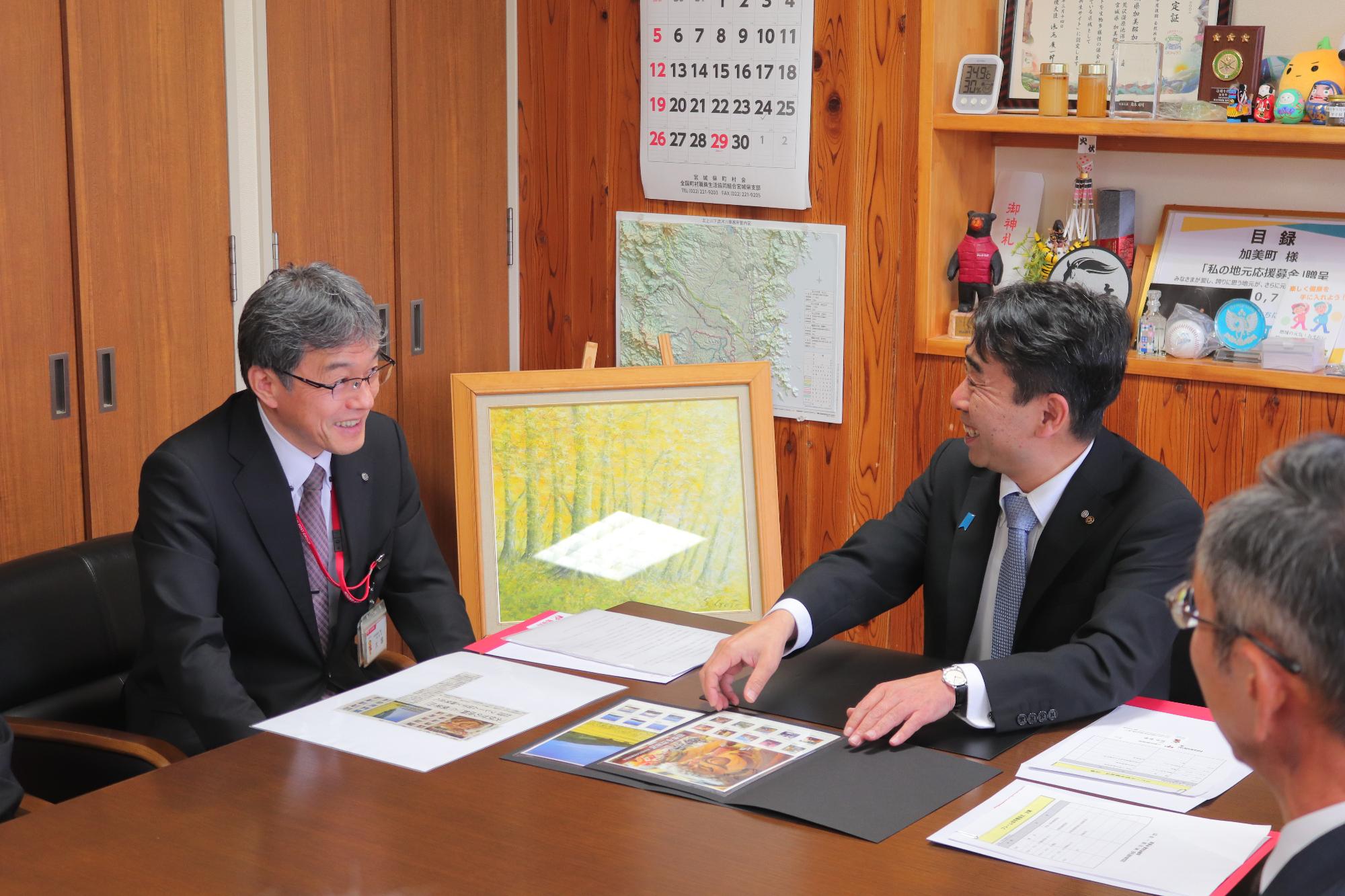切手を手に談笑する町長