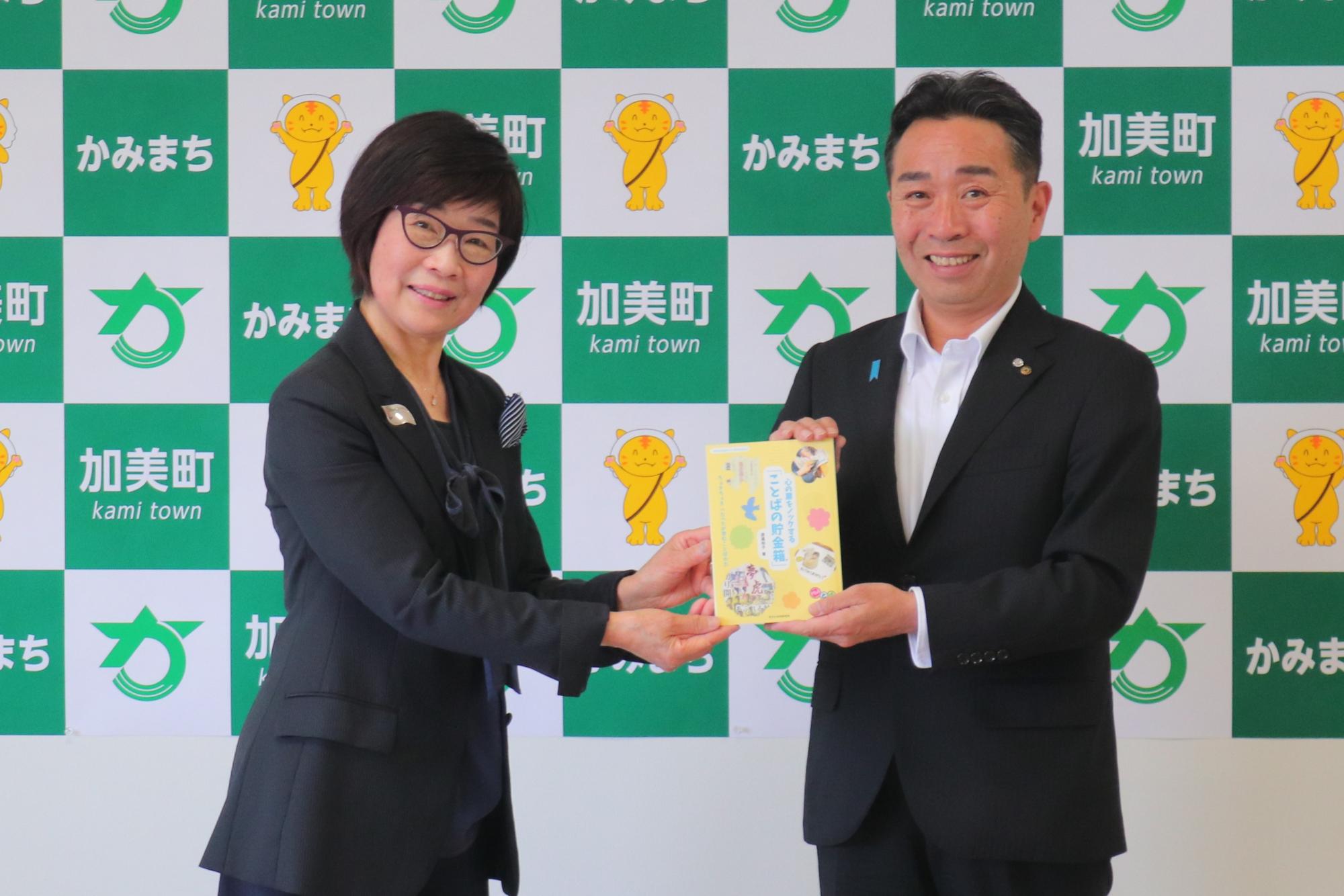 寄附された本を受け取る町長