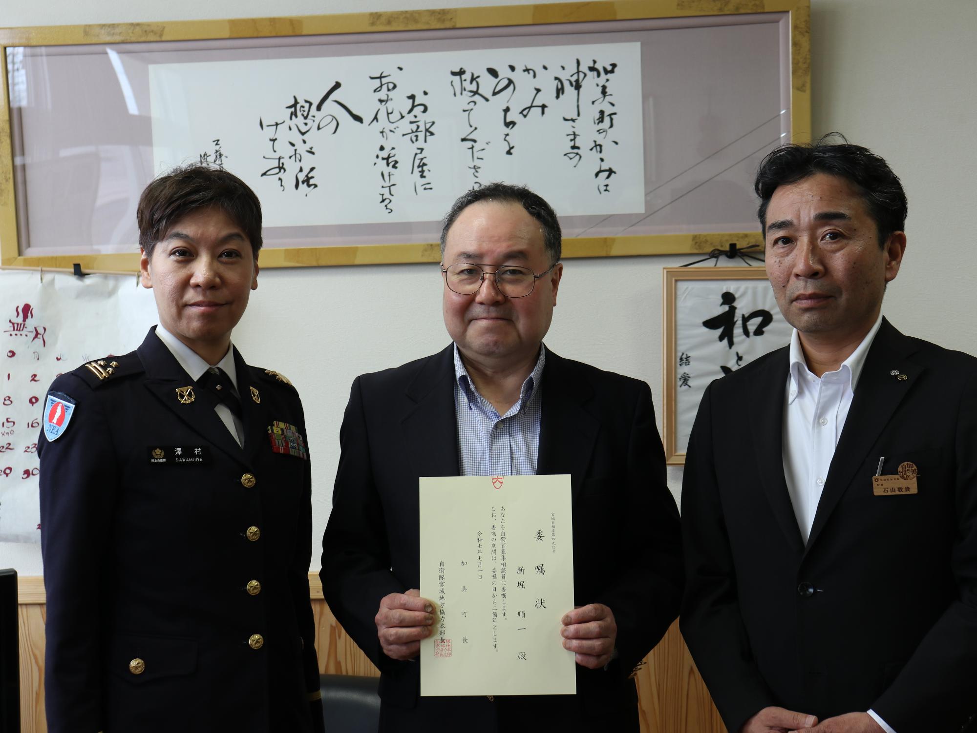 委嘱状を持った職員と