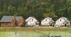 大自然の中、広いテニスコートが隣接するコテージの遠景写真