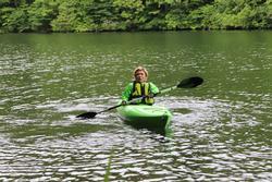 川で緑色のカヤックを漕いでいる人の写真