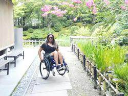 日本庭園の前で映る車椅子の女性の写真