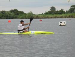 選手が黄色いカヌーに乗り、パドルを使って漕いでいる写真
