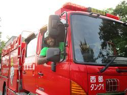 屋外で消防車に乗る男性の写真