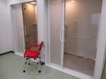 2部屋のシャワールームの前に赤い椅子が置かれている写真