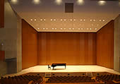 舞台の上にグラウンドピアノが置かれ、照明が当たっている写真