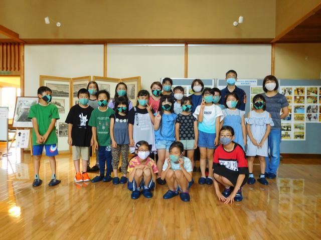 水色のマスクをつけた児童たちが並んで立っている写真