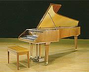 クリーム色のピアノと椅子の写真