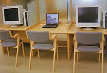 ノートパソコンとデスクトップ型のパソコンがテーブルに並べられている写真