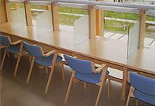 等間隔に椅子が並び、テーブルは仕切り板で区切られている「しらべデスク」の写真