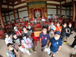 お寺の仏壇を背に、マスクをした生徒たちが集まって写っている写真